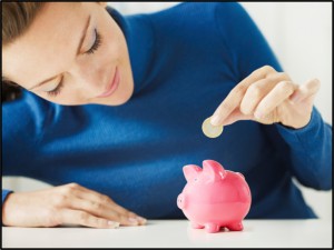 woman putting coin into piggy bank